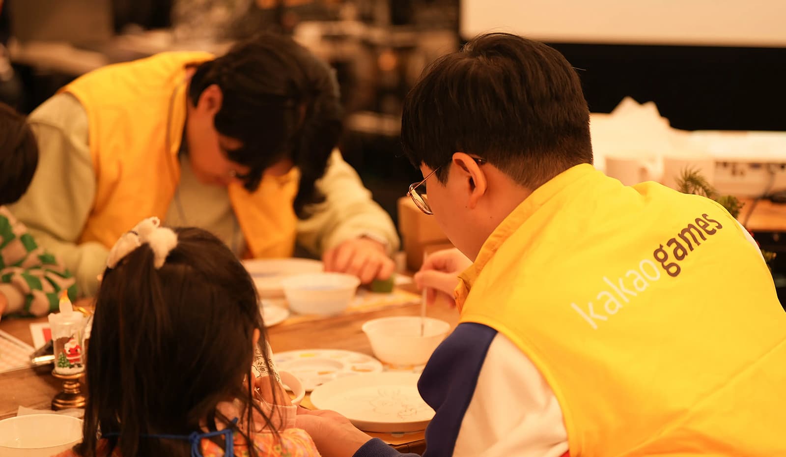 카카오게임즈 임직원들이 그룹홈 아이들과 함께 그릇 만들기 체험을 하고 있음